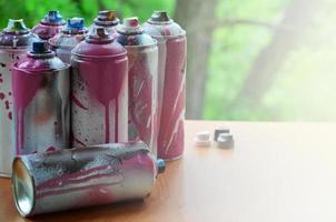 A lot of used spray cans of paint close-up. Dirty and smeared cans for drawing graffiti. The concept of a sweeping and careless drawing of paint. Creative art image photo