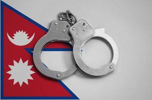 Nepal flag  and police handcuffs. The concept of observance of the law in the country and protection from crime photo