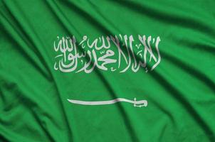 la bandera de arabia saudita está representada en una tela deportiva con muchos pliegues. bandera del equipo deportivo foto