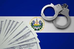 El Salvador flag  with handcuffs and a bundle of dollars. The concept of illegal banking operations in US currency photo