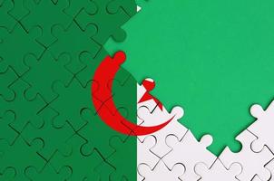 Algeria flag  is depicted on a completed jigsaw puzzle with free green copy space on the right side photo