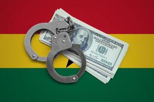 Ghana flag  with handcuffs and a bundle of dollars. Currency corruption in the country. Financial crimes photo