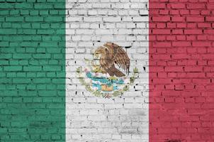 Mexico flag is painted onto an old brick wall photo