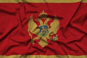 la bandera de montenegro está representada en una tela deportiva con muchos pliegues. bandera del equipo deportivo foto