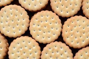 Detailed picture of round sandwich cookies with coconut filling. Background image of a close-up of several treats for tea photo