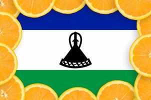 bandera de lesotho en marco de rodajas de cítricos frescos foto