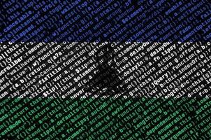 Lesotho flag  is depicted on the screen with the program code. The concept of modern technology and site development photo