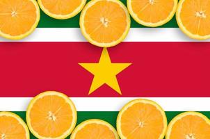 Suriname flag  in citrus fruit slices horizontal frame photo