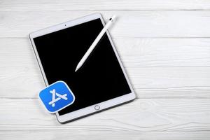 kharkiv, ucrania - 27 de enero de 2021 nuevo ipad de apple y lápiz de apple y logotipo azul de la tienda de aplicaciones sobre fondo blanco. Apple Inc. es una empresa de tecnología americana foto
