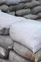 Background of many dirty sand bags for flood defense. Protective sandbag barricade for military use. Handsome tactical bunker photo