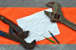 Adjustable wrenches and a sheet of paper with two pencils photo