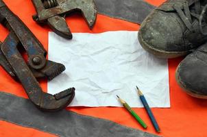 Adjustable wrenches with old boots and a sheet of paper with two photo