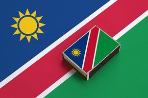 Namibia flag  is pictured on a matchbox that lies on a large flag photo