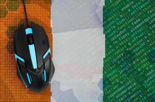 Ivory Coast flag  and computer mouse. Digital threat, illegal actions on the Internet photo