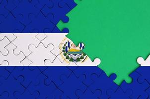 la bandera de el salvador se representa en un rompecabezas completo con espacio de copia verde libre en el lado derecho foto