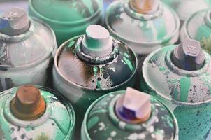 A lot of used spray cans of paint close-up. Dirty and smeared cans for drawing graffiti. The concept of a sweeping and careless drawing of paint. Creative art image photo