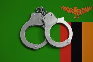 Zambia flag  and police handcuffs. The concept of observance of the law in the country and protection from crime photo