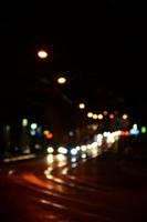 escena nocturna borrosa de tráfico en la carretera. imagen desenfocada de coches que viajan con faros luminosos. arte bokeh foto