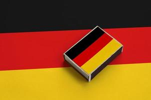 Germany flag  is pictured on a matchbox that lies on a large flag photo