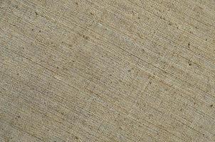 Texture of a gray canvas made of old and coarse burlap. Top view photo