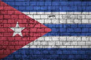 Cuba flag is painted onto an old brick wall photo