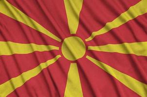 Macedonia flag  is depicted on a sports cloth fabric with many folds. Sport team banner photo