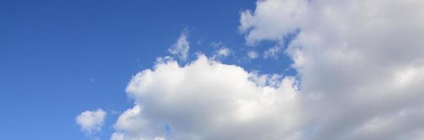 A blue sky with lots of white clouds of different sizes photo