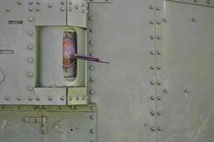 la textura de la pared del depósito, realizada en metal y reforzada con multitud de tornillos y remaches. imágenes de la cobertura de un vehículo de combate de la segunda guerra mundial con una ametralladora guiada foto