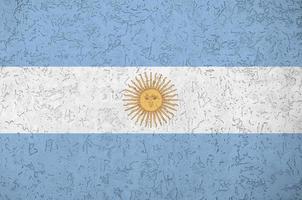 Argentina flag depicted in bright paint colors on old relief plastering wall. Textured banner on rough background photo