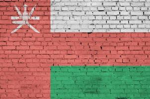 Oman flag is painted onto an old brick wall photo