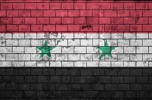 la bandera de siria está pintada en una pared de ladrillo vieja foto