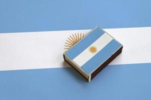 Argentina flag  is pictured on a matchbox that lies on a large flag photo