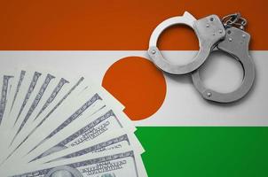 Niger flag  with handcuffs and a bundle of dollars. The concept of illegal banking operations in US currency photo