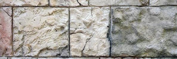 Fragment of ancient walls of fortification with large boulders close up photo