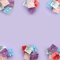 Piles of a small colored gift boxes with ribbons lies on a violet background. Minimalism flat lay top view pattern photo