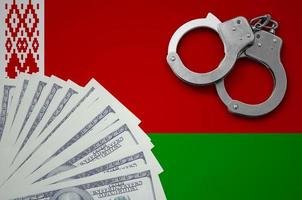 Belarus flag  with handcuffs and a bundle of dollars. The concept of illegal banking operations in US currency photo