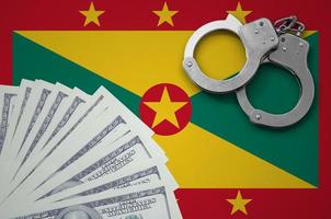 Grenada flag  with handcuffs and a bundle of dollars. The concept of illegal banking operations in US currency photo