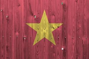 Vietnam flag depicted in bright paint colors on old wooden wall. Textured banner on rough background photo