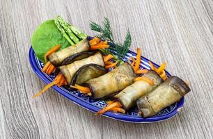 Eggplant rolls in a bowl on wooden background photo