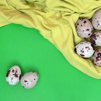 Quail eggs on a light green surface, top view, empty place for t photo