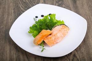 Steamed salmon on the plate and wooden background photo