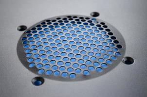 Close-up, shallow focus of a meshed style cooling panel used on a main frame computer. The circular holes aid active venting of hot air within the computer photo