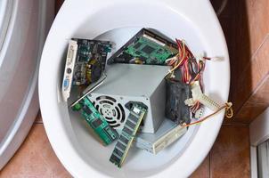 los detalles de la computadora vieja y sin usar se reciclan en la taza del inodoro foto