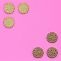 Pattern of a brown biscuits on a pink background. Trendy minimal concept of food and dessert. Abstract flat lay, top view photo