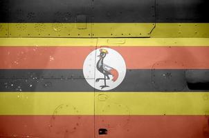 Uganda flag depicted on side part of military armored helicopter closeup. Army forces aircraft conceptual background photo