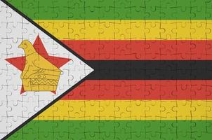 Zimbabwe flag  is depicted on a folded puzzle photo