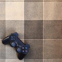 Video game controller lies on a checkered plaid photo