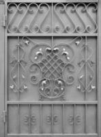 The texture of the silver metal gate with a beautiful floral pattern of forged metal photo