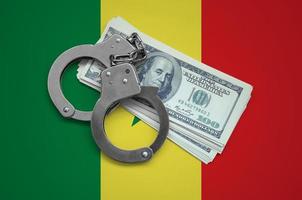 Senegal flag  with handcuffs and a bundle of dollars. Currency corruption in the country. Financial crimes photo