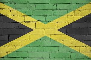 Jamaica flag is painted onto an old brick wall photo